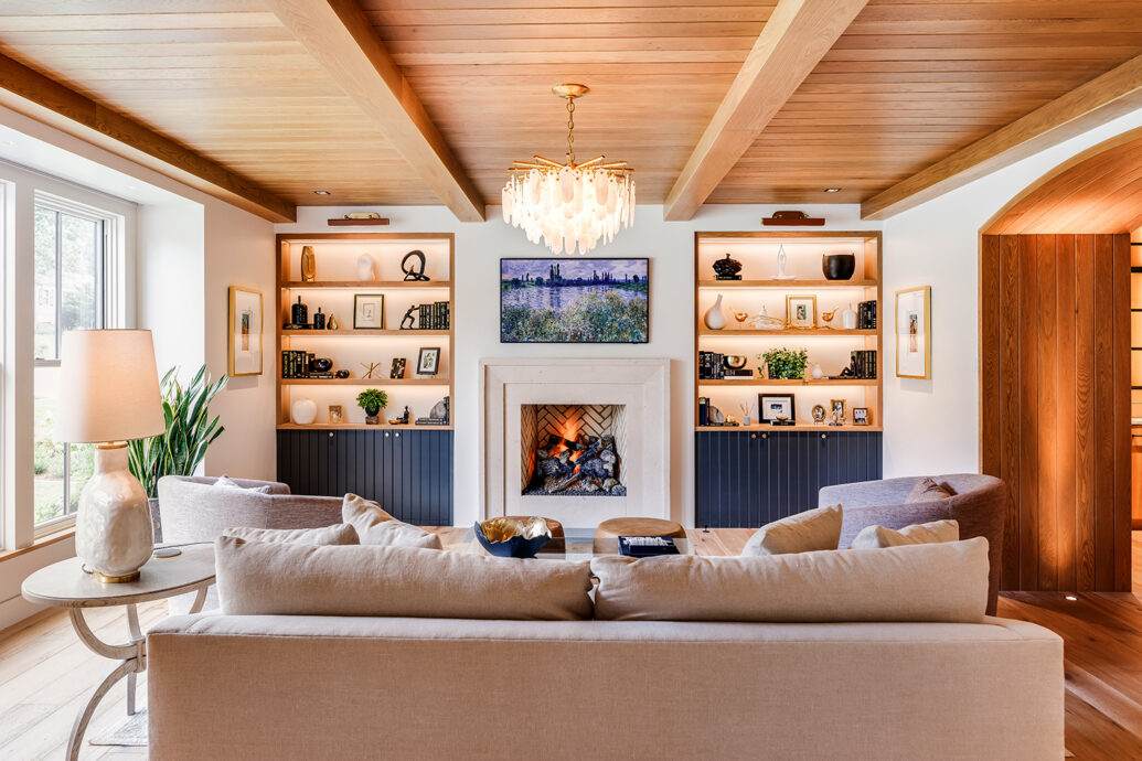 Warm modern style living room, carved stone fireplace surround, white oak floors, built by luxury home builder Bluestone Construction